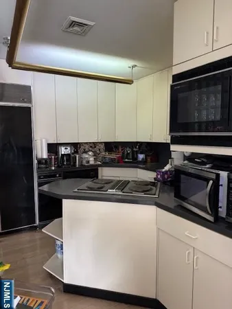 a kitchen with stainless steel appliances granite countertop a stove and a microwave
