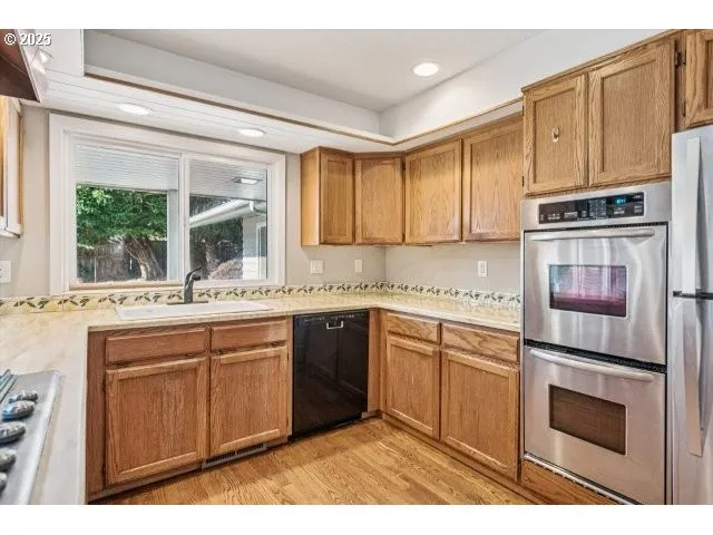 a kitchen with granite countertop a sink stainless steel appliances and cabinets