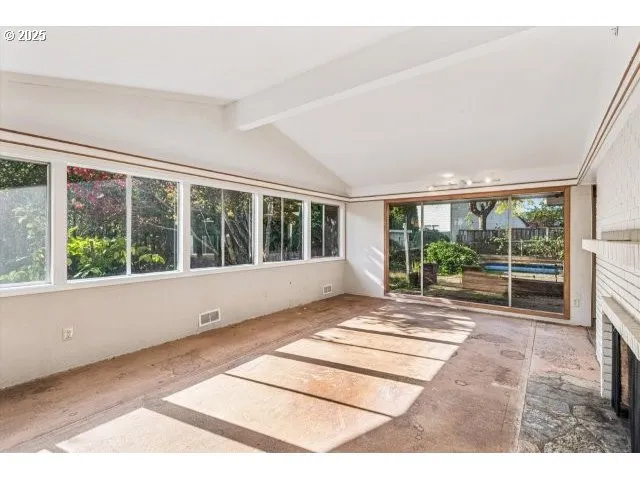 a view of an empty room with wooden floor and a floor to ceiling window