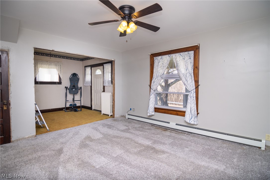 53341 Key Bellaire Road Bellaire, OH 43906 - Photo 12 of 48 Exercise room featuring baseboard heating, radiator heating unit, light carpet, and a ceiling fan