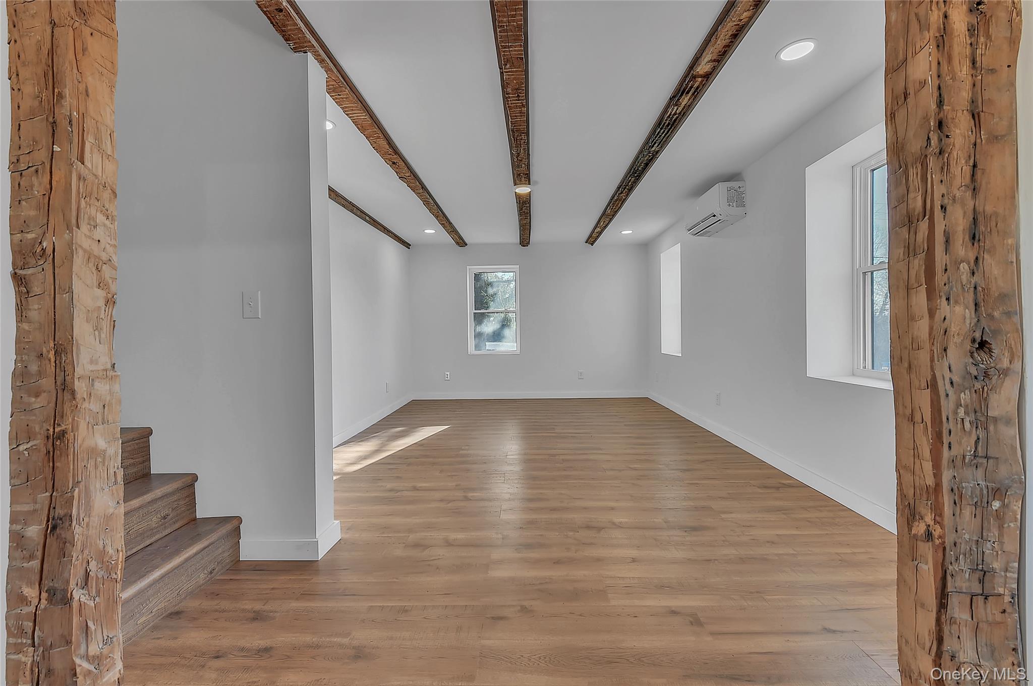 67 Jacobs Road Westtown, NY 10998 - Photo 17 of 35 Unfurnished living room with recessed lighting, beam ceiling, light wood-style floors, and an AC wall unit