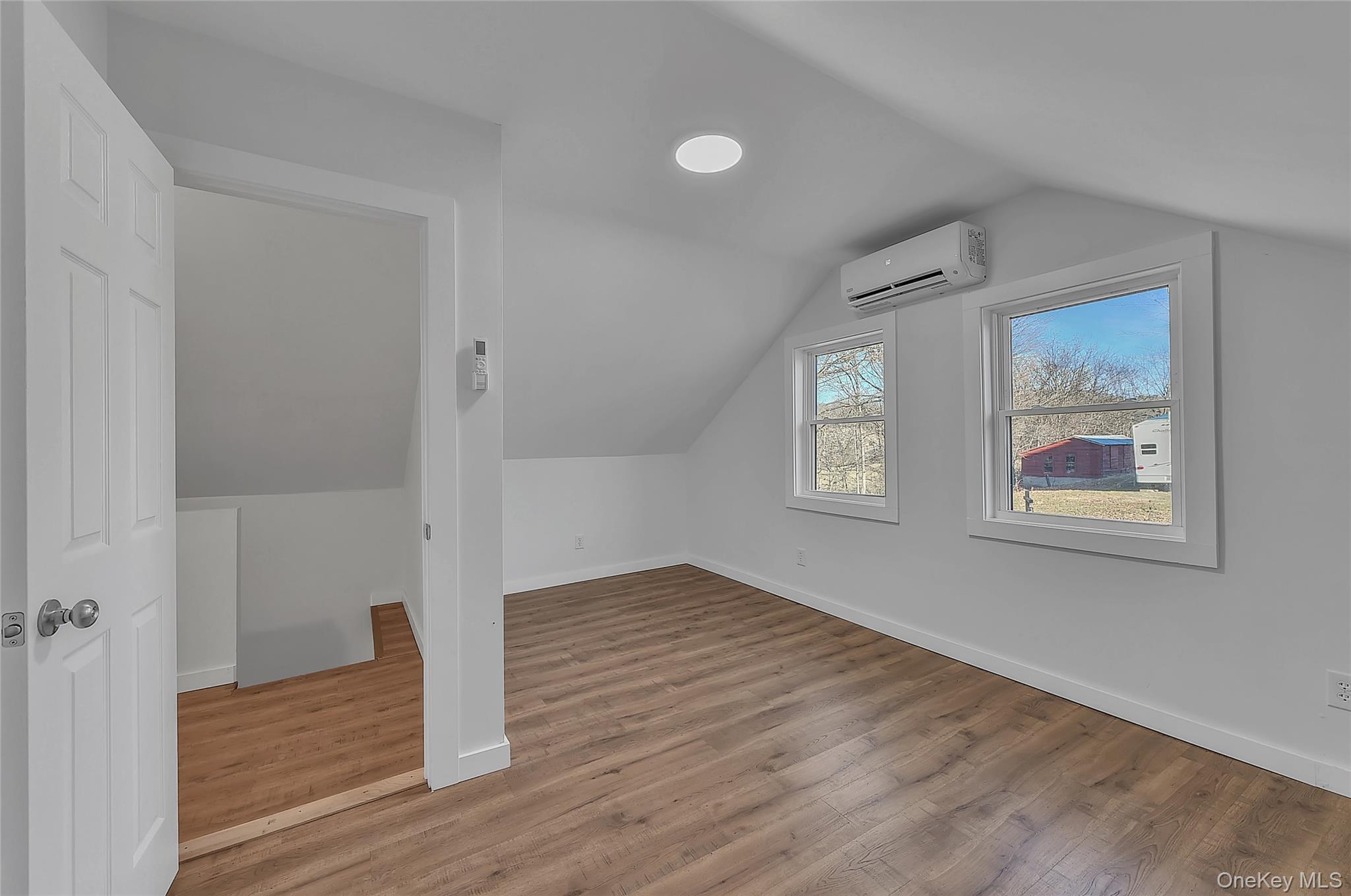 67 Jacobs Road Westtown, NY 10998 - Photo 22 of 35 Additional living space with vaulted ceiling, light wood-style floors, and a wall unit AC