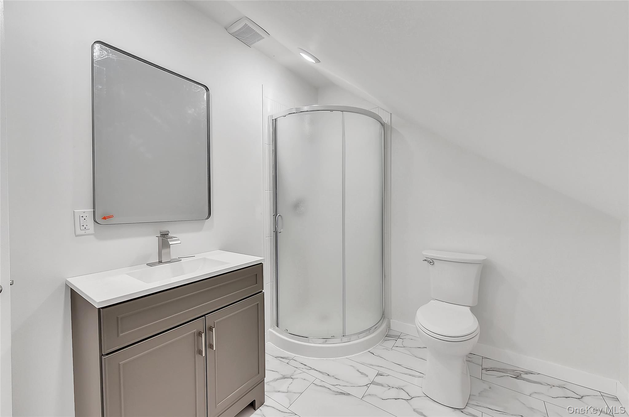 67 Jacobs Road Westtown, NY 10998 - Photo 27 of 35 Full bath featuring light marble finish flooring, vanity, a stall shower, and vaulted ceiling