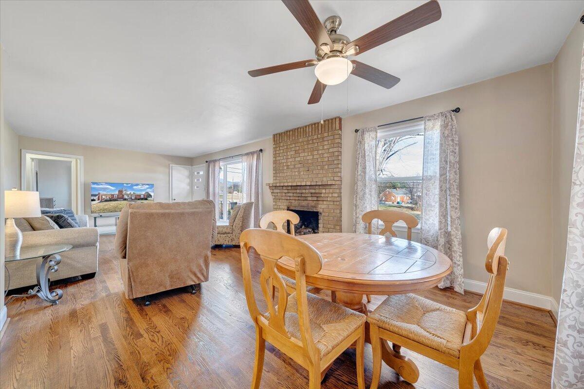 3808 Cove Road Roanoke, VA 24017 - Photo 8 of 34 a view of a dining room with furniture a fireplace and wooden floor