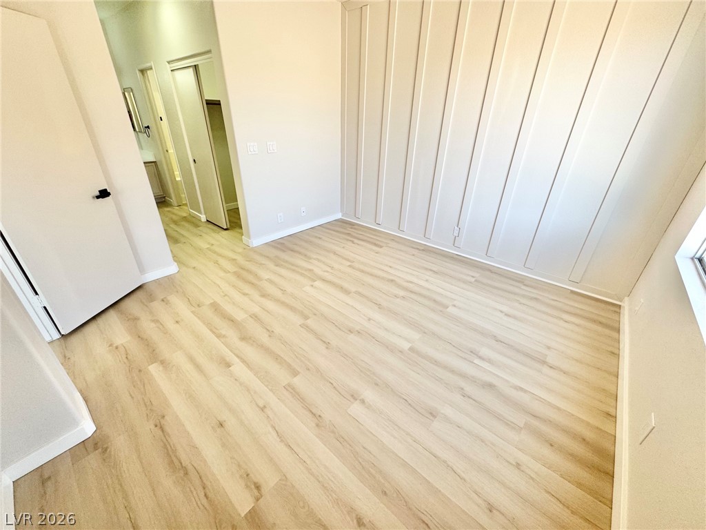 7340 Ridge Star Court Las Vegas, NV 89131 - Photo 20 of 22 Board and batten accent wall frames this naturally illuminated bedroom with resilient flooring.