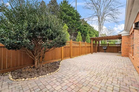 a view of an empty room with wooden floor fireplace and a window