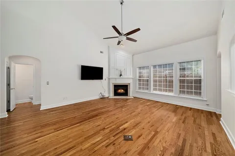 a view of empty room with wooden floor and fireplace