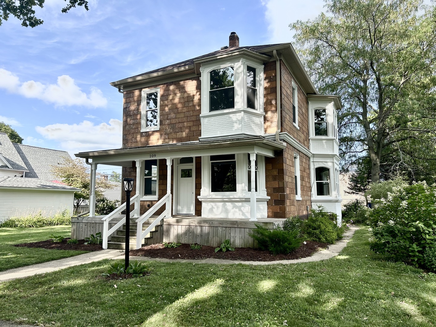 a front view of a house with a yard and potted plants