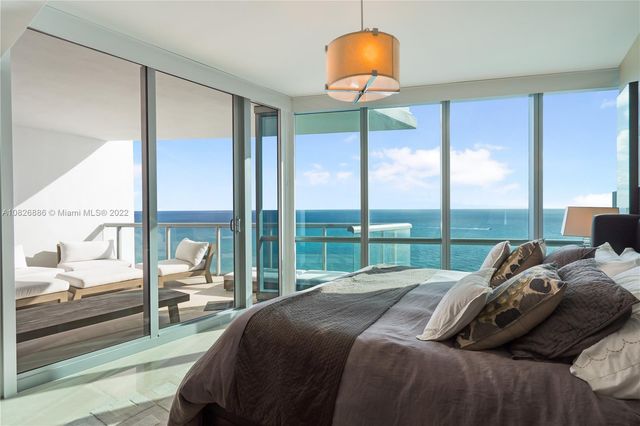 a large bedroom with a bed and large window