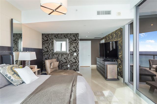 a living room with furniture and floor to ceiling windows