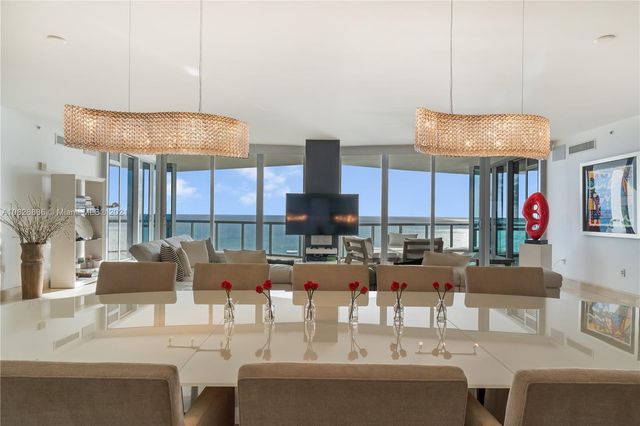 a living room with furniture a flat screen tv and a large window