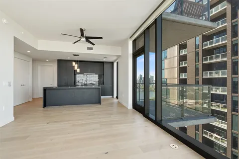 a living room with stainless steel appliances granite countertop a refrigerator and a sink