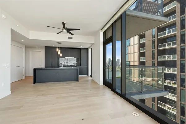 a living room with stainless steel appliances granite countertop a refrigerator and a sink