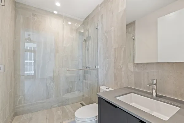 an empty room with wooden floor and windows with curtains