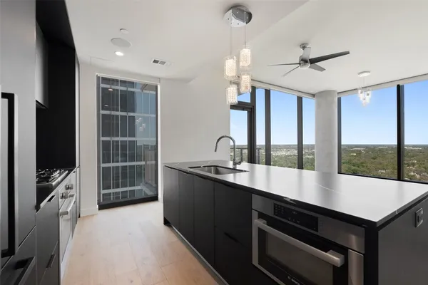 a large kitchen with kitchen island a sink stainless steel appliances and a counter top space