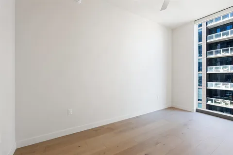 an empty room with windows and cabinet