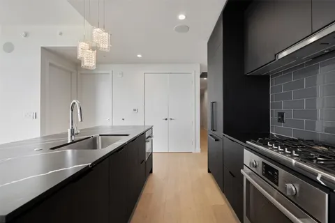 a kitchen with granite countertop a sink stainless steel appliances and cabinets