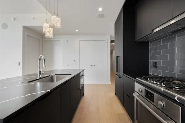 a kitchen with granite countertop a sink stainless steel appliances and cabinets
