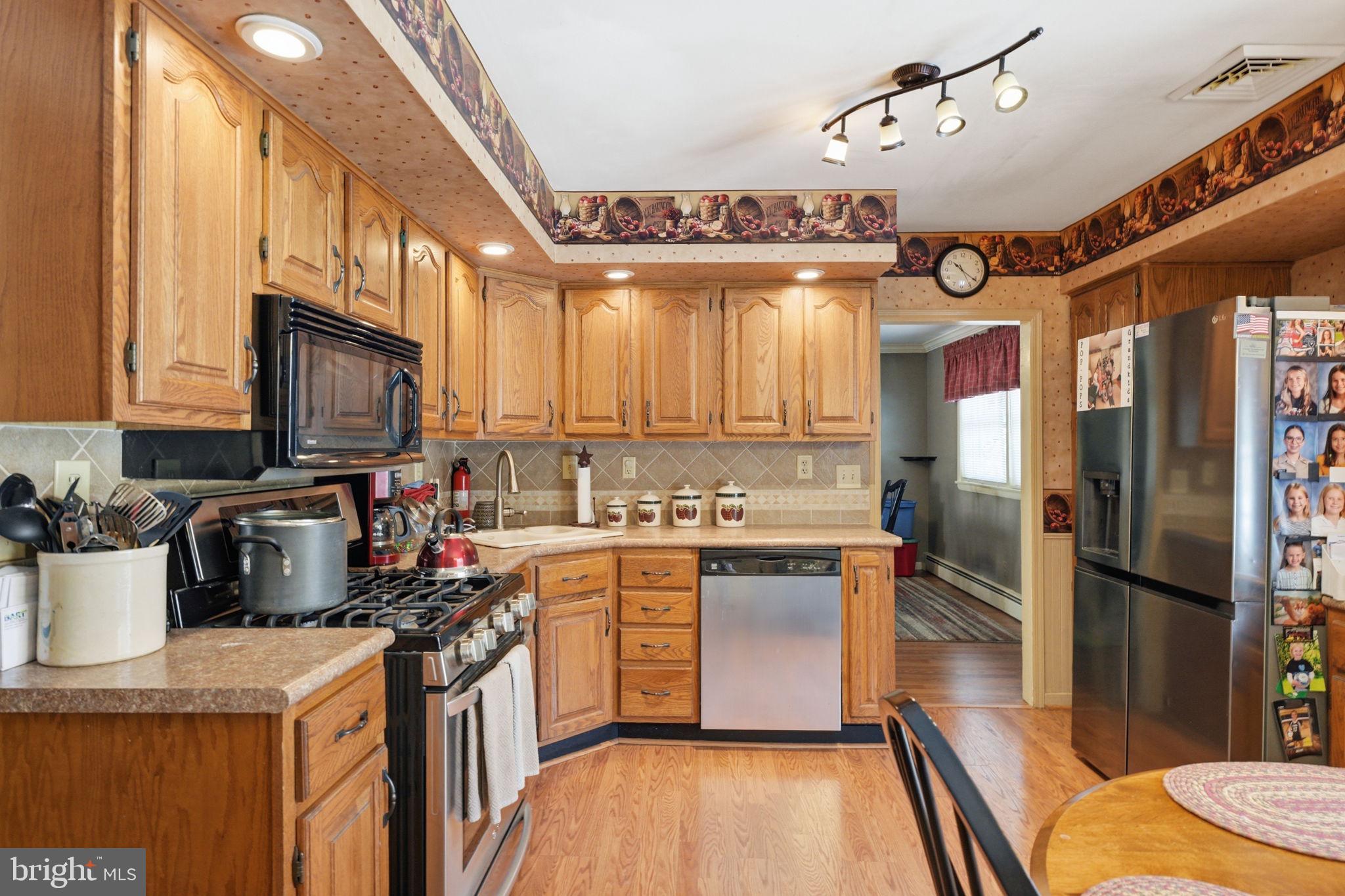 1848 Brackenville Road Hockessin, DE 19707 - Photo 8 of 37 a kitchen with stainless steel appliances granite countertop a stove a sink dishwasher and a refrigerator with wooden floor