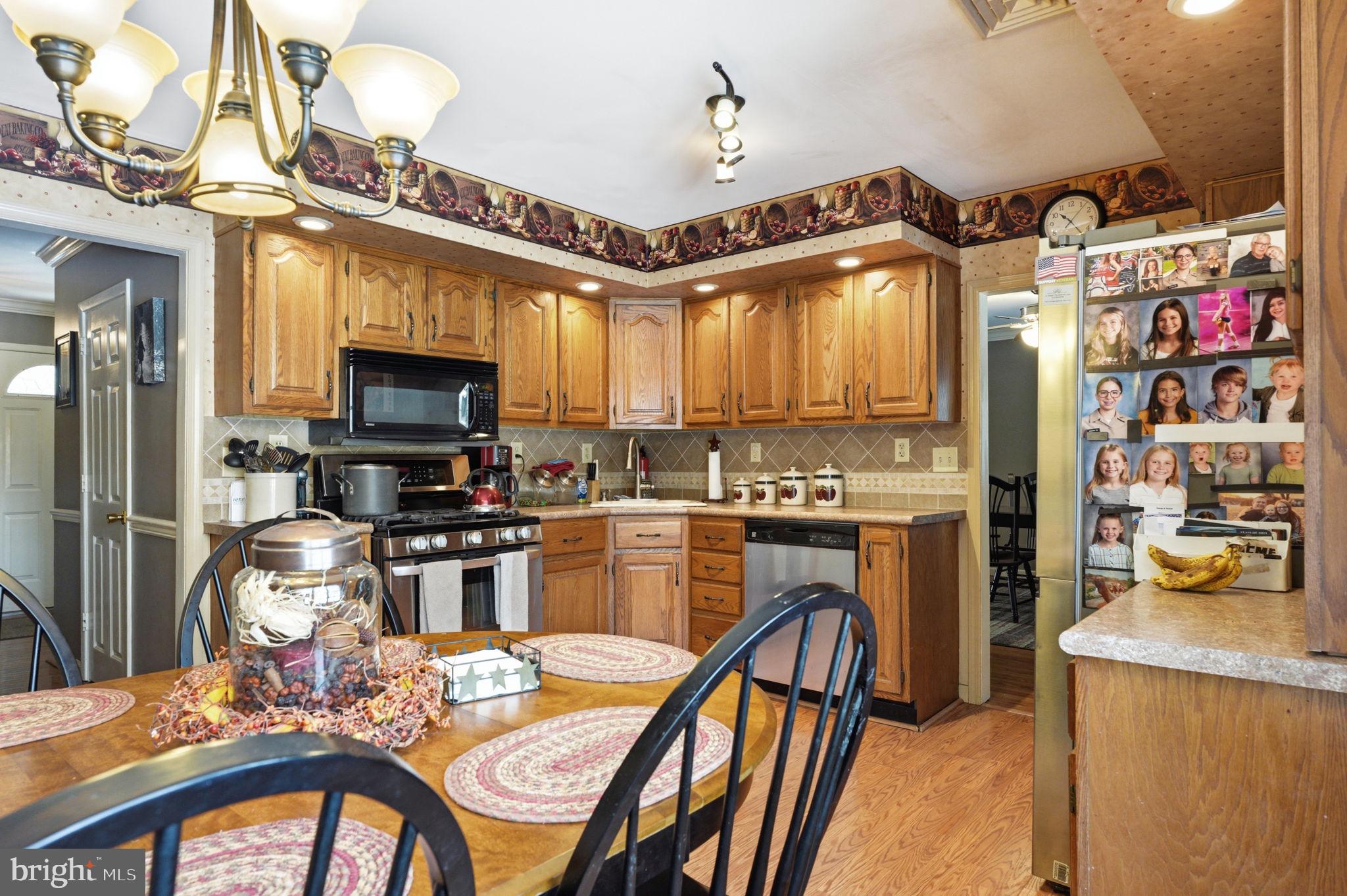 1848 Brackenville Road Hockessin, DE 19707 - Photo 10 of 37 a kitchen with stainless steel appliances granite countertop a stove top oven a sink dishwasher a dining table and chairs with wooden floor