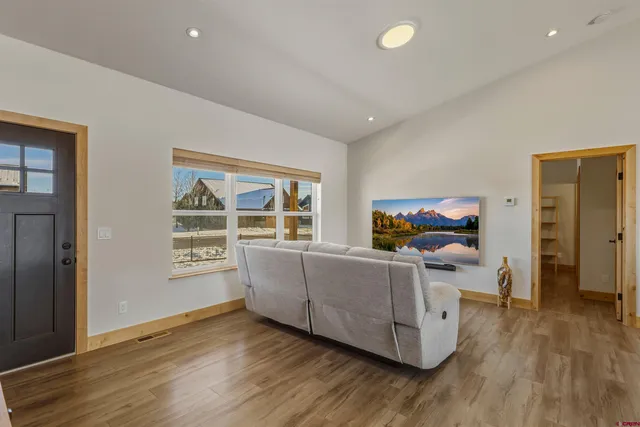 a living room with stainless steel appliances kitchen island granite countertop a couch and white cabinets