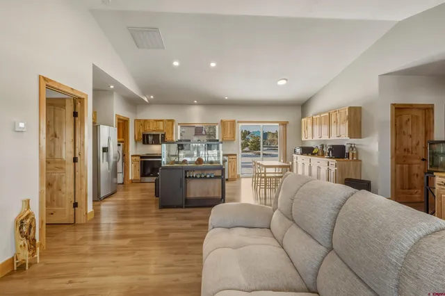a large kitchen with stainless steel appliances kitchen island granite countertop a refrigerator and cabinets