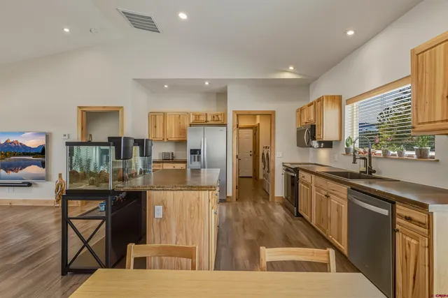 a kitchen with stainless steel appliances granite countertop a sink stove and refrigerator