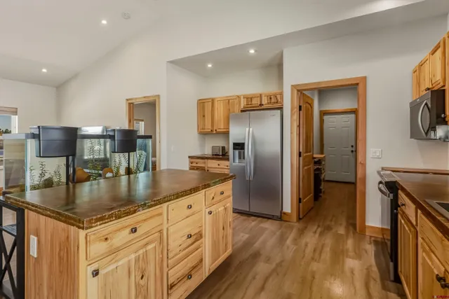 a kitchen with stainless steel appliances granite countertop a sink stove microwave and refrigerator