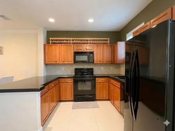 a kitchen with stainless steel appliances granite countertop a refrigerator a stove top oven a sink and dishwasher