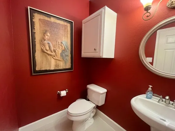 a bathroom with a toilet sink and mirror