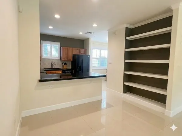 a view of kitchen with cabinets and window