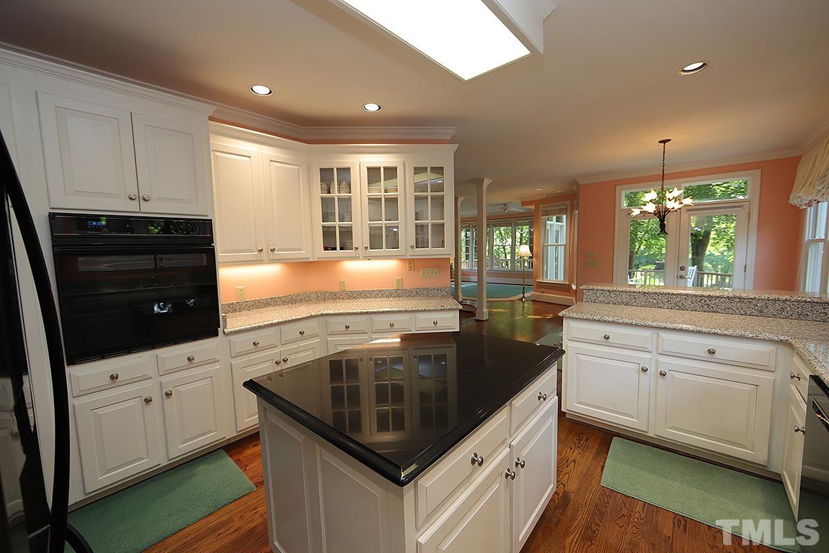 7600 Pinewild Court Raleigh, NC 27615 - Photo 21 of 52 a kitchen with granite countertop white cabinets and appliances