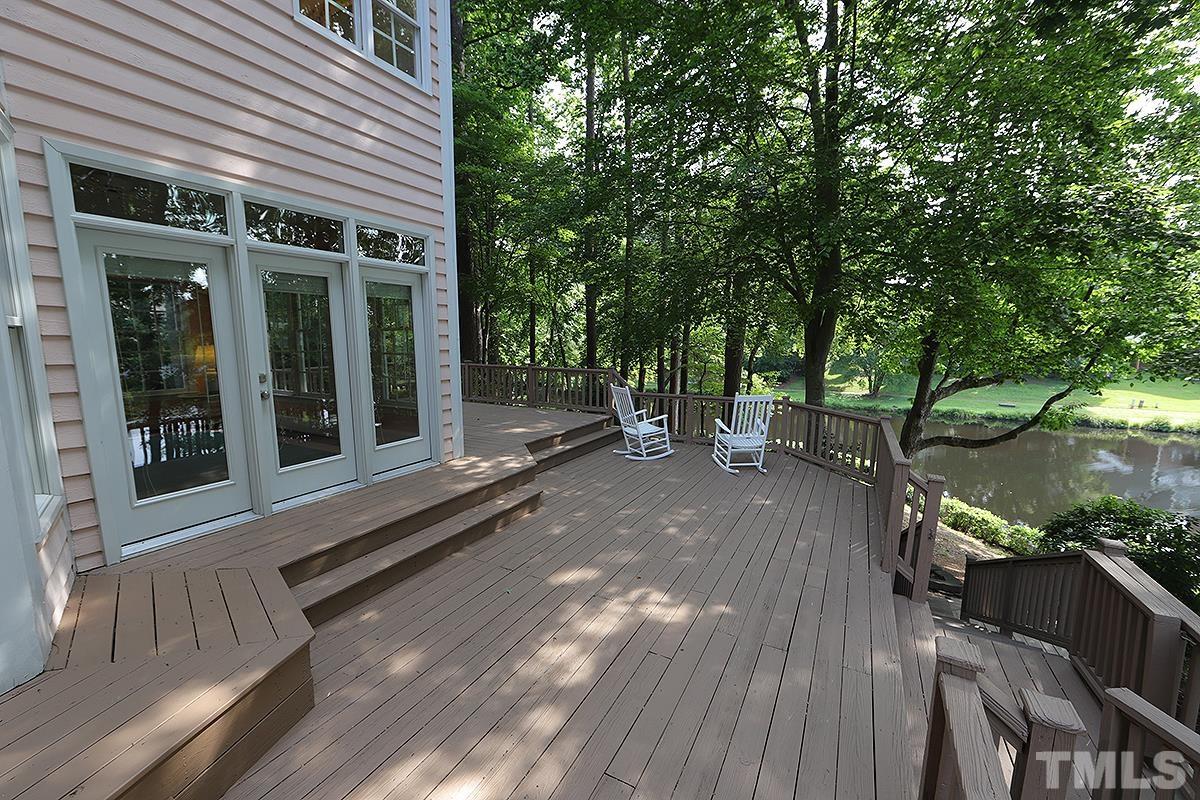 7600 Pinewild Court Raleigh, NC 27615 - Photo 43 of 52 a view of a house with floor to ceiling windows and a large tree
