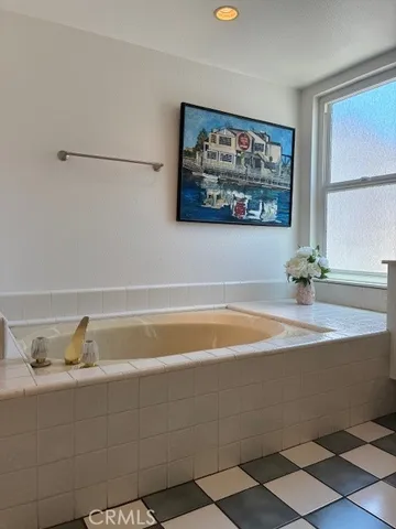 a bathroom with a bathtub and a picture on the wall