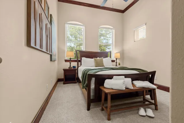 a bed sitting in a spacious bedroom next to a window