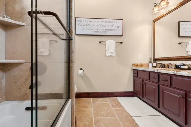 a bedroom with a bed lamp and paintings on the wall