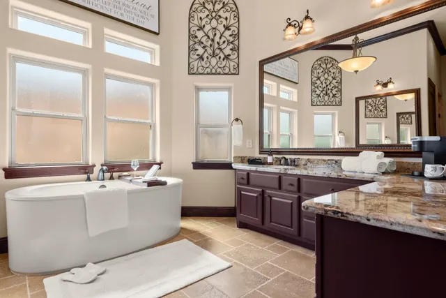a spacious bathroom with a vanity a mirror and a bathtub