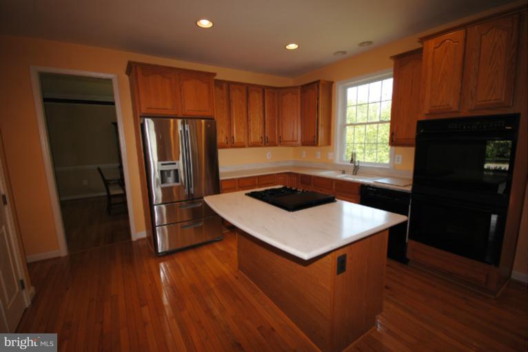 20334 Cliftons Point Street Sterling, VA 20165 - Photo 20 of 30 a kitchen with wooden cabinets and refrigerator