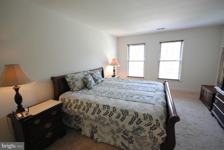 20334 Cliftons Point Street Sterling, VA 20165 - Photo 6 of 30 a bed sitting in a bedroom next to a window