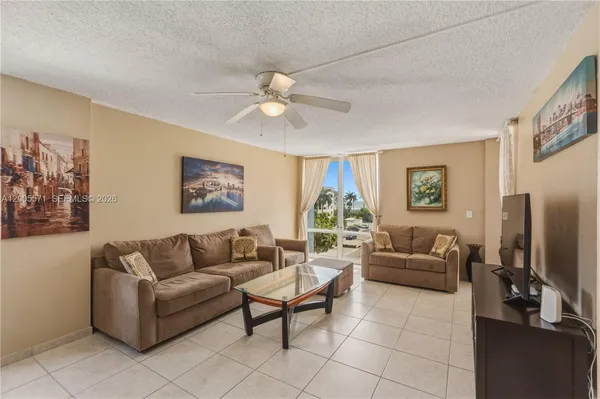 a living room with furniture a flat screen tv and a window