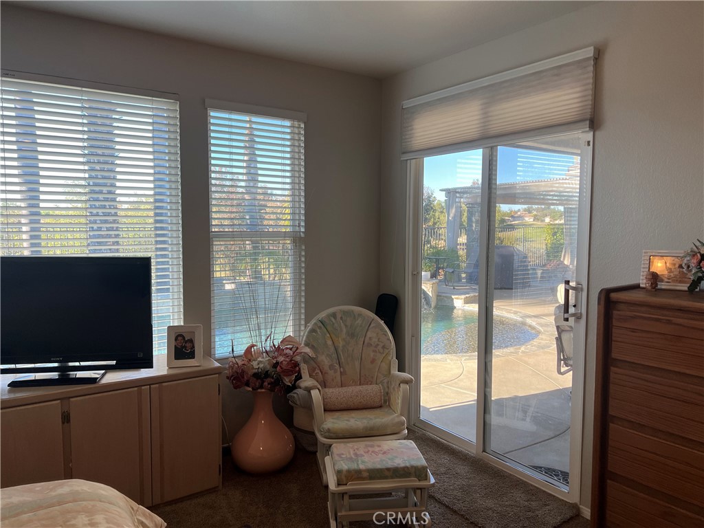 31458 Inverness Court Temecula, CA 92591 - Photo 19 of 33 a living room with furniture tv and a floor to ceiling window