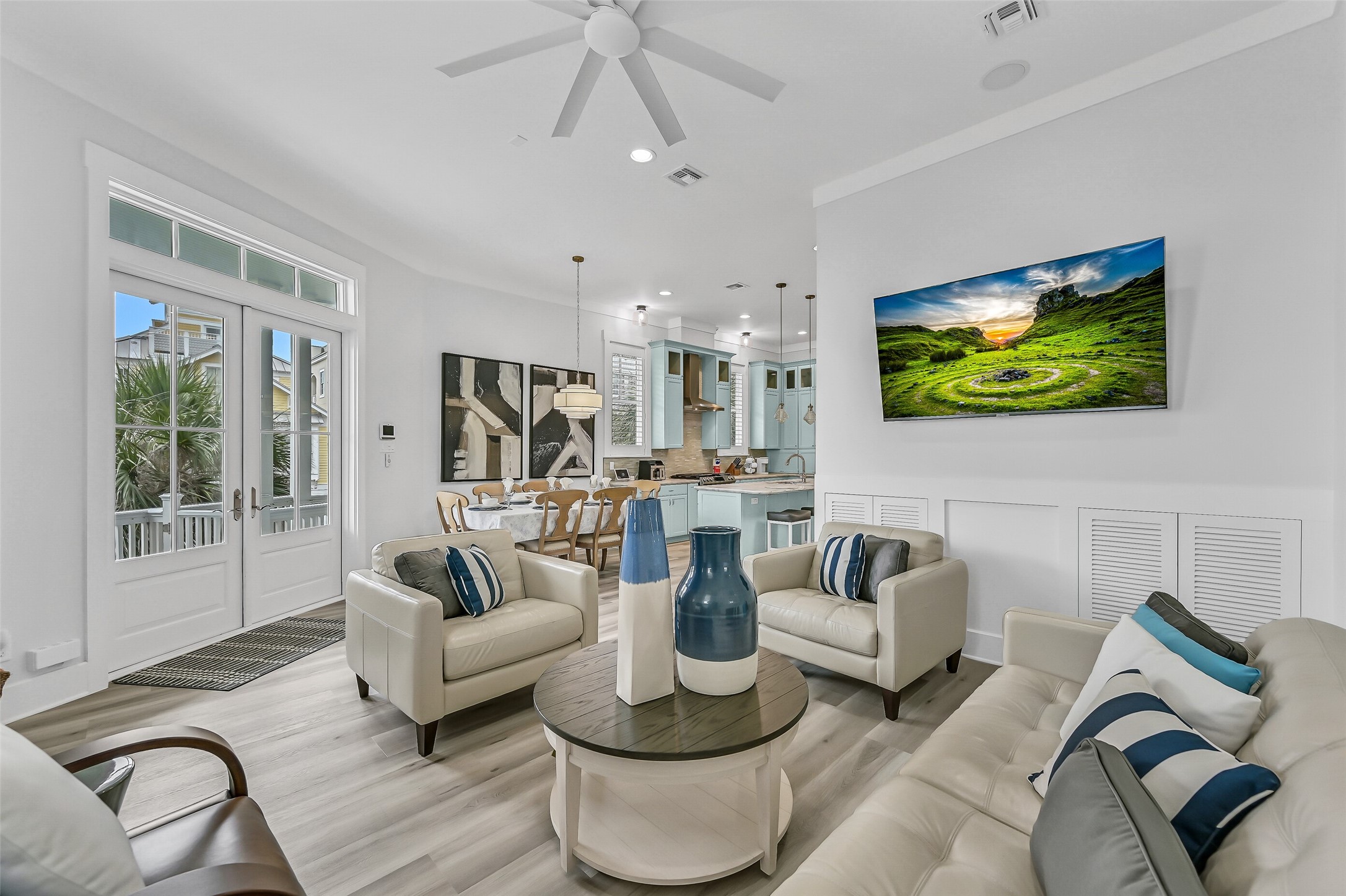 817 Positano Road Galveston, TX 77550 - Photo 13 of 50 The open-concept design seamlessly connects the living, dining, and kitchen spaces, creating an ideal setting for gathering and entertaining. Updated furnishings and new coastal-inspired flooring enhance the home's fresh, airy feel while maintaining effortless flow throughout.