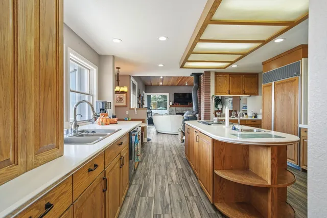 a large kitchen with kitchen island granite countertop a large window and stainless steel appliances