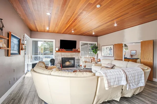 a living room with furniture a fireplace and a flat screen tv