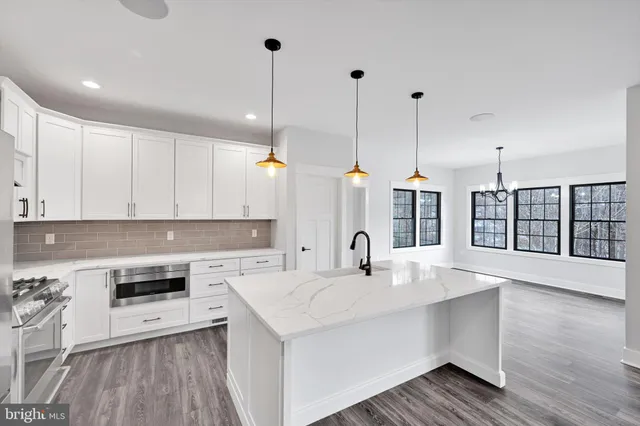 a view of a hallway with wooden floor staircase and a living room