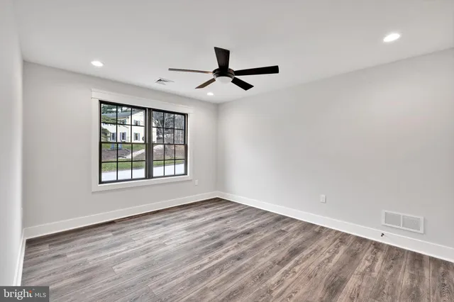 a view of an empty room with wooden floor