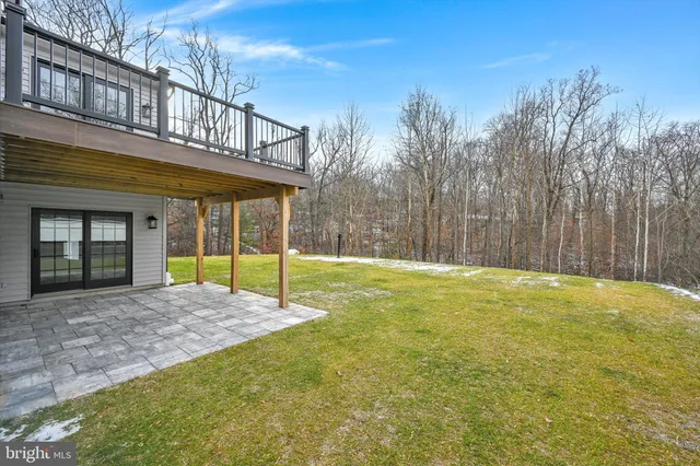 a front view of a house with a big yard and large trees