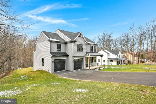 a view of an empty room with wooden floor a ceiling fan and a fireplace