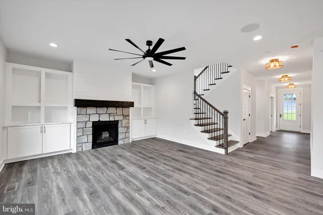 a view of an empty room with a kitchen and wooden floor