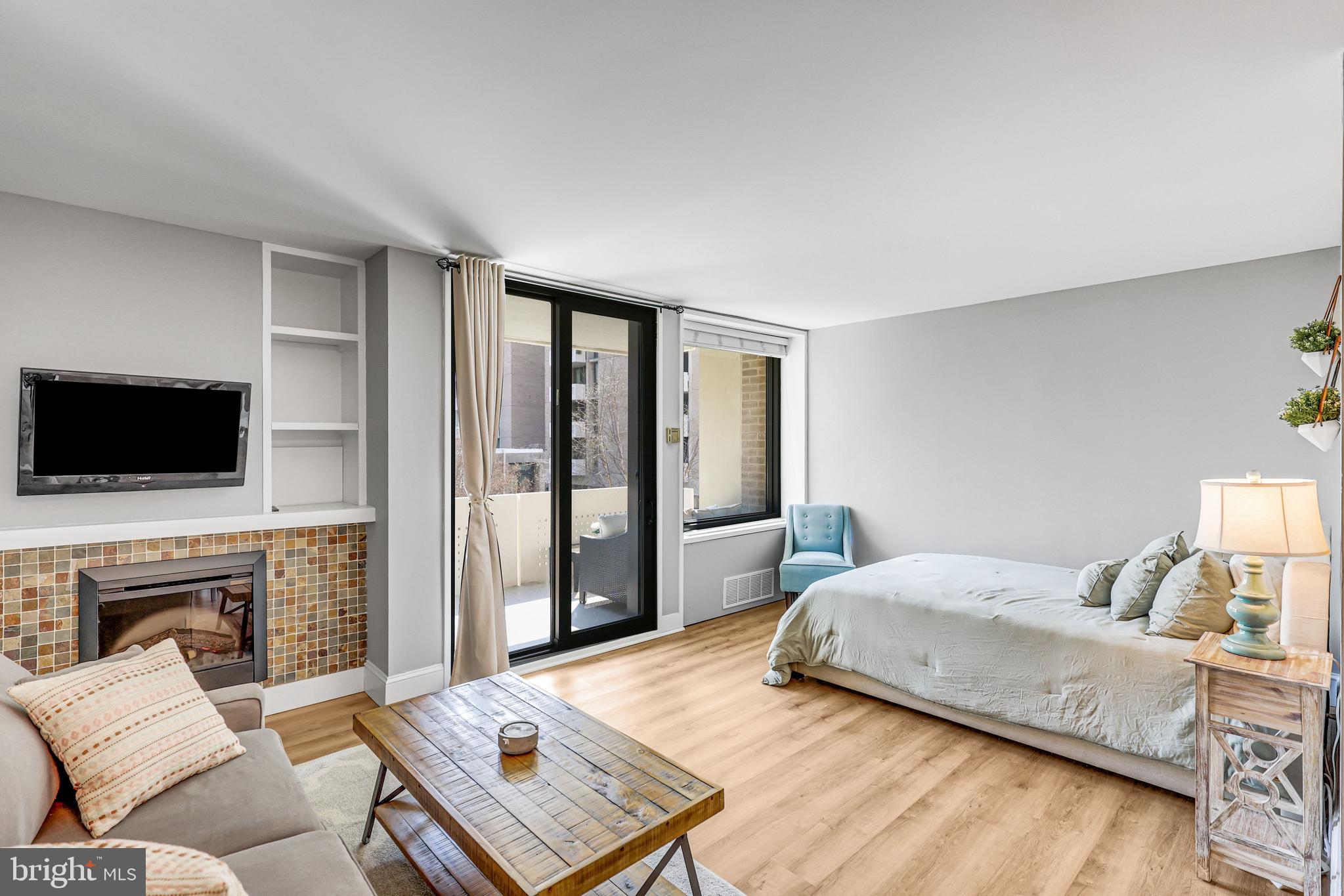 a bedroom with a bed a flat screen tv and a couch